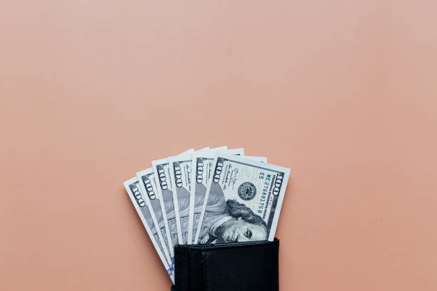 istock Bundle of dollars in purse on beige background 1302751348
