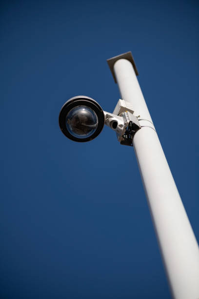 istock Street surveillance camera on a white metal pole 1302752275