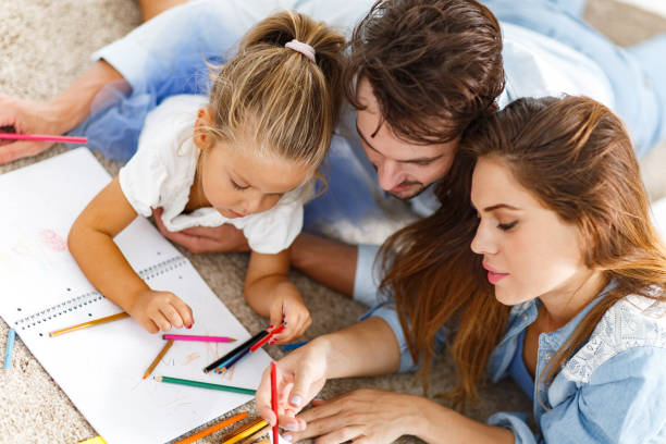 istock Young parents drawing with their small daughter at home. 1302754400