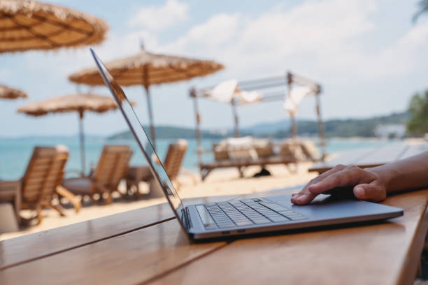 istock a woman working and touching on laptop touchpad on the beach 1302754475