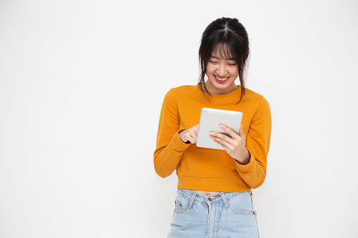 Happy asian woman smile and holding tablet isolated on white background