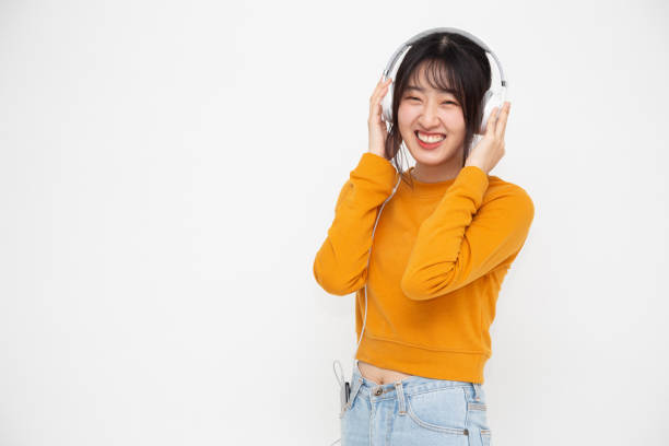 joven mujer de belleza asiática escuchando música con auriculares en la aplicación de canciones de lista de reproducción en el teléfono inteligente aislado en fondo blanco - samba dancing audio fotografías e imágenes de stock