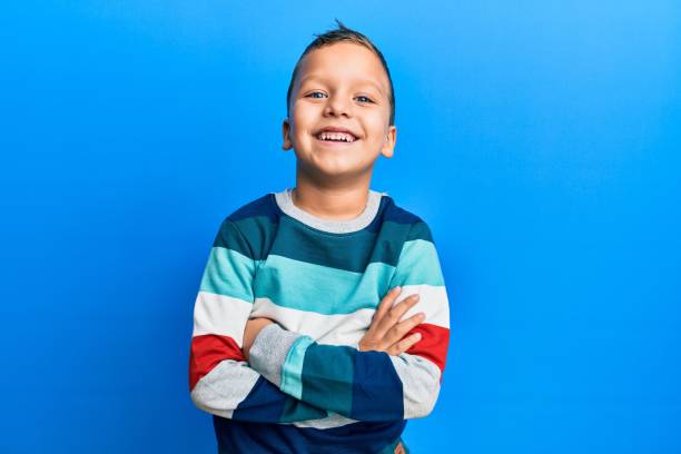 Little kid boy wearing striped sweater happy face smiling with crossed arms looking at the camera. positive person. Little kid boy wearing striped sweater happy face smiling with crossed arms looking at the camera. positive person. 6 7 years stock pictures, royalty-free photos & images