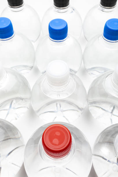 istock Background of transparent spherical water bottles with colored caps. 1302756515
