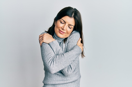 Young hispanic woman wearing casual clothes hugging oneself happy and positive, smiling confident. self love and self care