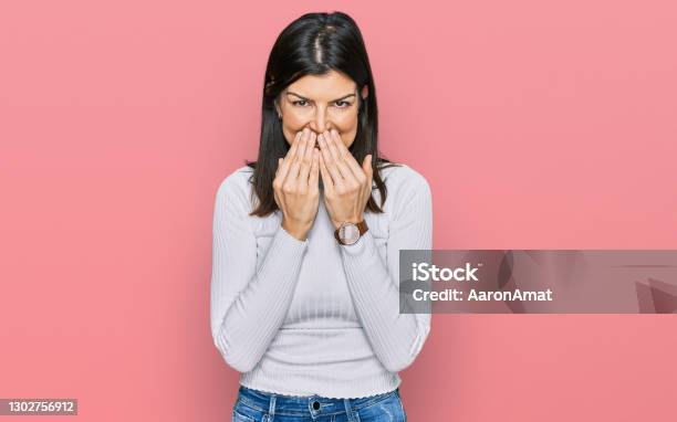 Beautiful Brunette Woman Wearing Casual Clothes Laughing And Embarrassed Giggle Covering Mouth With Hands Gossip And Scandal Concept Stock Photo - Download Image Now