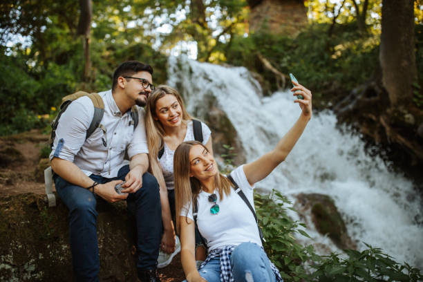 istock Young friends taking selfie by waterfall 1302759023