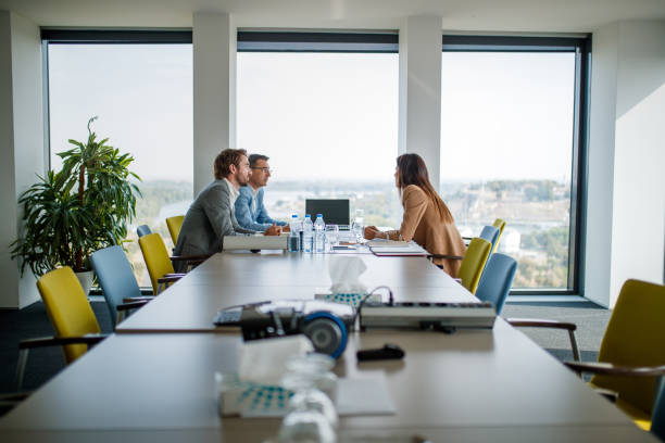 istock Managers sitting in board room on higher floor, discussing business 1302759366