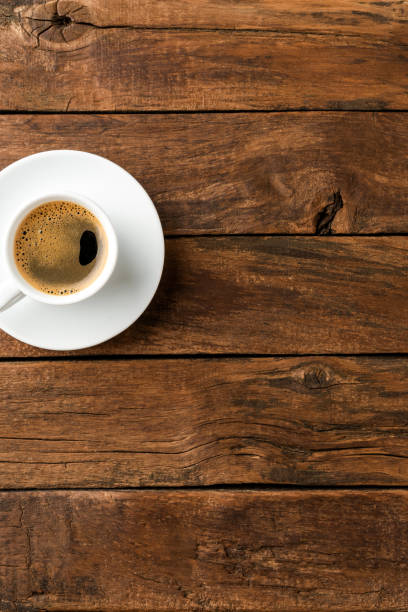istock Black coffee cup on retro wooden background with copyspace. Top view 1302763399