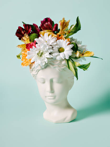 istock Antique head statue with fresh spring flowers on bright mint background 1302764391