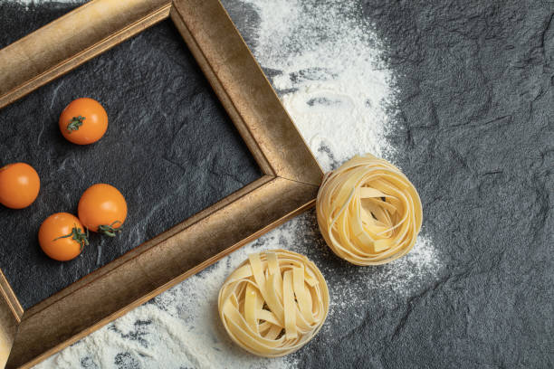 Raw nest pasta with flour and cherry tomatoes