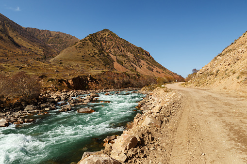 The A367 highway runs along the Kokemeren River in the Jayyl District. Kyrgyzstan.