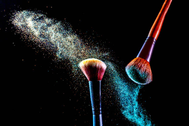 istock Make up cosmetic brushes with colorful shadows explosion on black background. Skin care or fashion concept. 1302772062