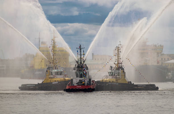 dancing tugboats on the neva river. marine festival of icebreakers in saint petersburg, russia - water cannon imagens e fotografias de stock