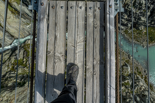 Top down view of a person walking on a suspension bridge in Switzerland