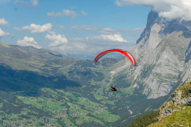istock Red para glider flying in Swiss Alps. 1302775581