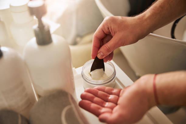 Stylist hands using a spatula for a hairstyling product