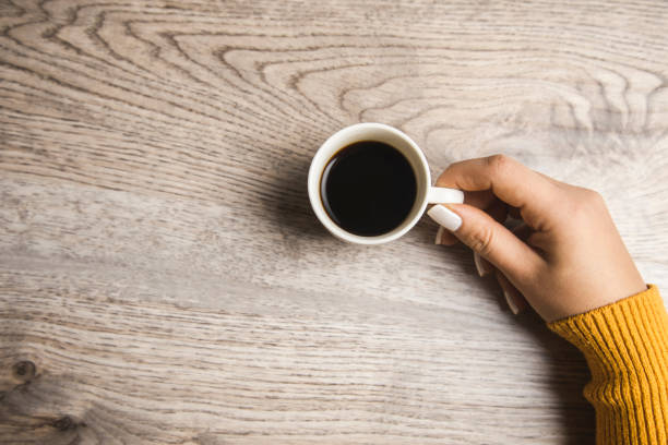 istock woman holding cup of coffee 1302779058
