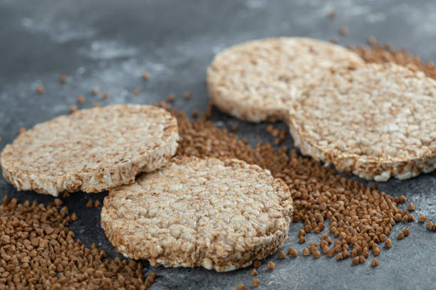 istock Puffed crispbread and raw buckwheat on marble surface 1302779301