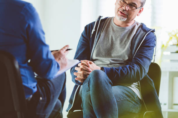 istock Mature man talking with psychotherapist in his office 1302781350