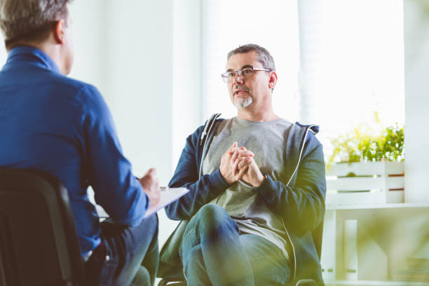 Mature man talking with psychotherapist in his office