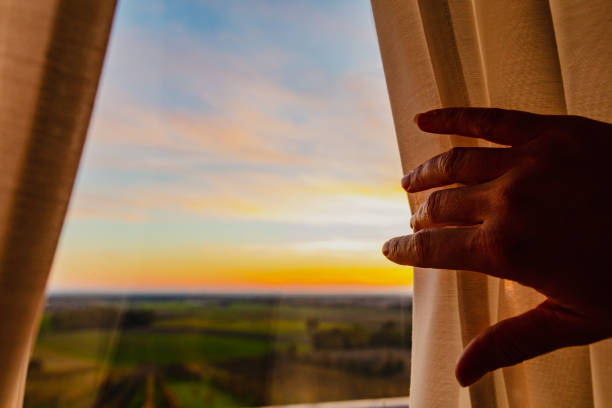 istock Woman hand holding window curtain 1302782127