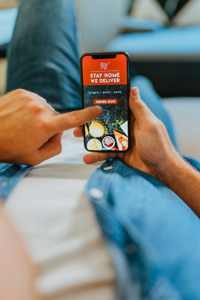 istock Man ordering food online using mobile app at home 1302782355