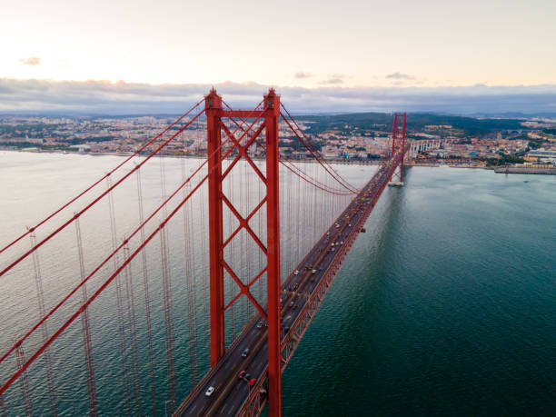 April 25th Bridge at sunset, Almada, Lisboa Region, Portugal Aerial view shot of the April 25th Bridge and the Tagus River at sunset, Almada, Lisboa Region, Portugal lisbon photos stock pictures, royalty-free photos & images