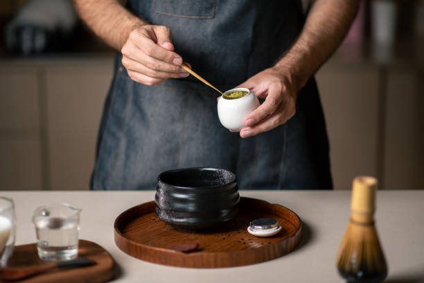 istock Man making matcha green tea with traditional accessories closeup 1302783856