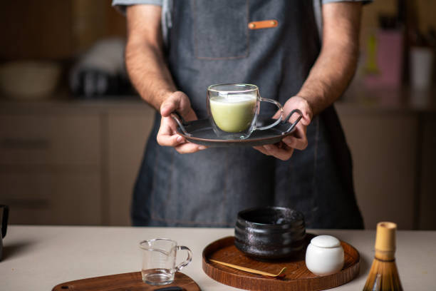 新鮮な抹茶ラテ緑茶飲料を提供する男 - latté coffee tray froth ストックフォトと画像