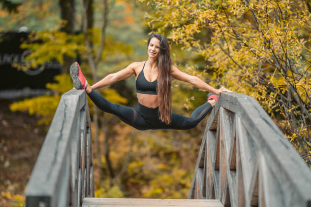 istock Young woman doing stretching exercise on railings in the nature 1302785380