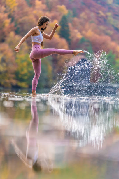 istock Young woman kicking lake water 1302785385