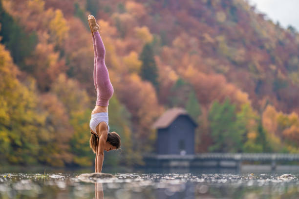 istock Young woman doing handstand in lake 1302785401