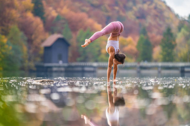 istock Young woman doing handstand in lake 1302785464