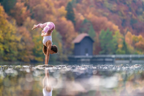 istock Young woman doing handstand in lake 1302785470