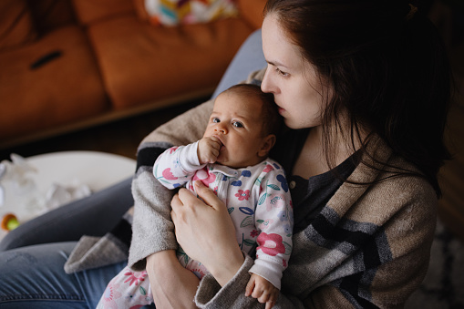 Young mother bonding with her newborn baby daughter