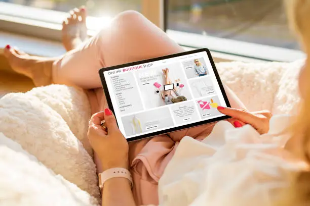 Photo of Woman using tablet and shopping online on boutique fashion store
