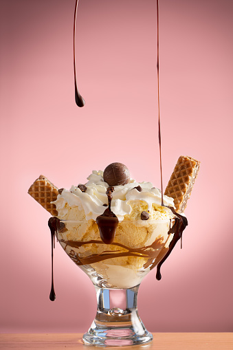 Prepared Chocolate Ice-cream Sundae with spilling chocolate syrup in a studio shot