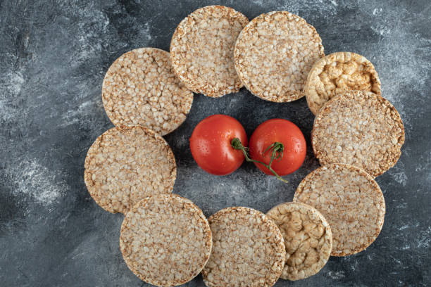 istock Pile of crispbread and fresh tomatoes on marble surface 1302790113