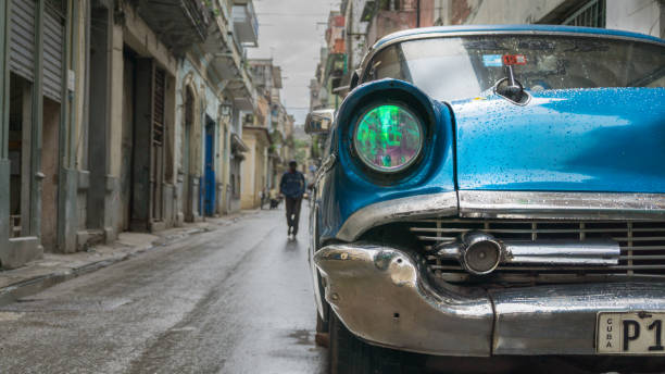 Havana, Cuba-December 2017: Vintage American car on the streets of Havana's Old Quarter with a man in the background getting closer.
