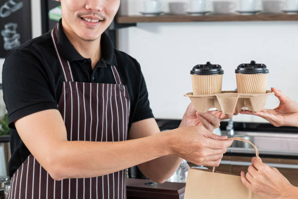 istock Bartender serving passing hot drinks to female customer at coffee shop. 1302791879