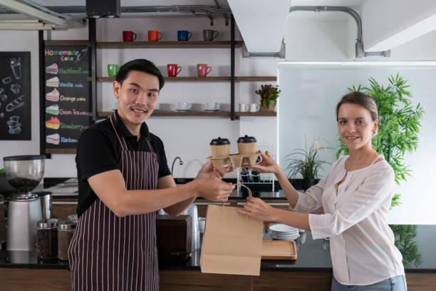 istock Bartender serving passing hot drinks to female customer at coffee shop. 1302791882