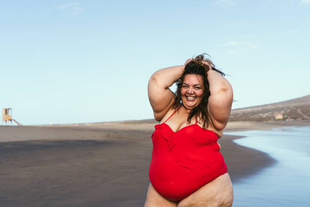 istock Happy plus size woman posing on the beach - Curvy overweight model having fun during vacation in tropical destination - Over size confident person concept 1302792081