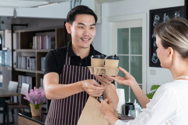 istock Bartender serving passing hot drinks to female customer at coffee shop. 1302792085