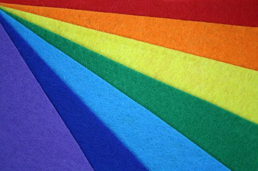 The background is made of felt of rainbow colors. Top view.