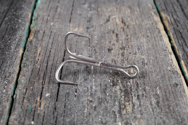 istock fishing triple hook on wooden background, close-up, selective focus 1302793943