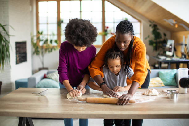 istock Mother bonding with her little daughters in kitchen 1302795122