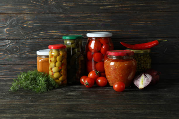 istock Jars with different canned food on wooden background 1302795201