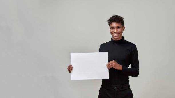 istock Cheerful young african american man holding empty poster 1302795538