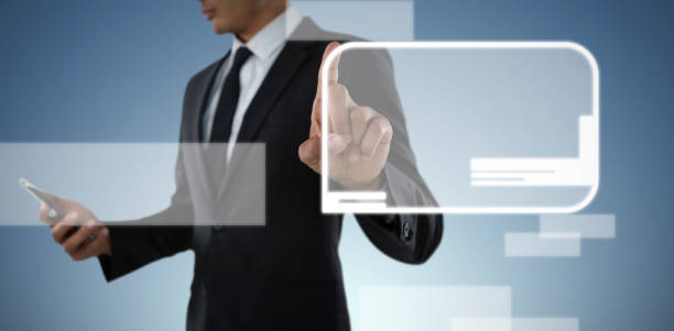 istock Mid section of businessman using phone while touching invisible interface against abstract blue back 1302795654